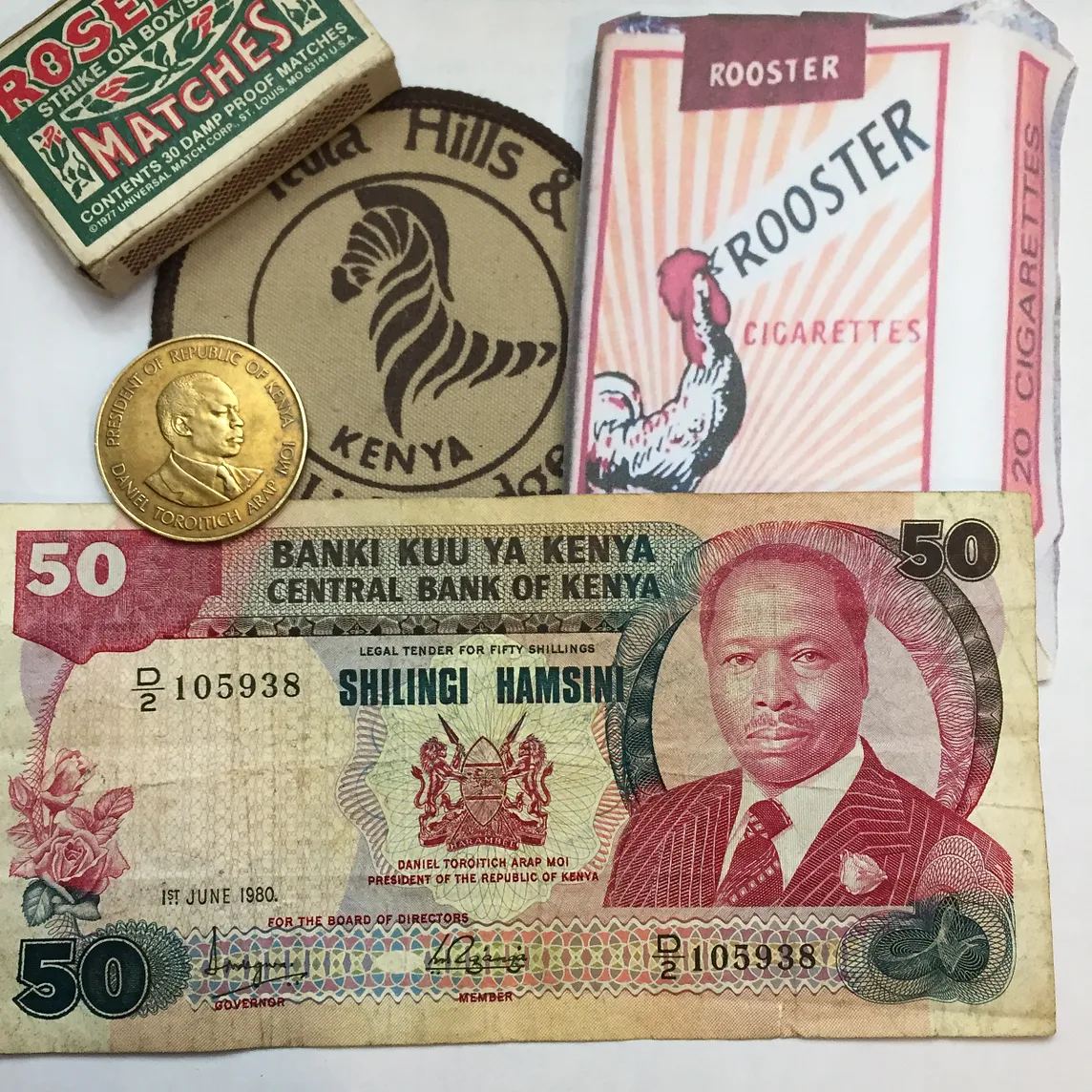 cigarettes, paper money, and a coin from Kenya