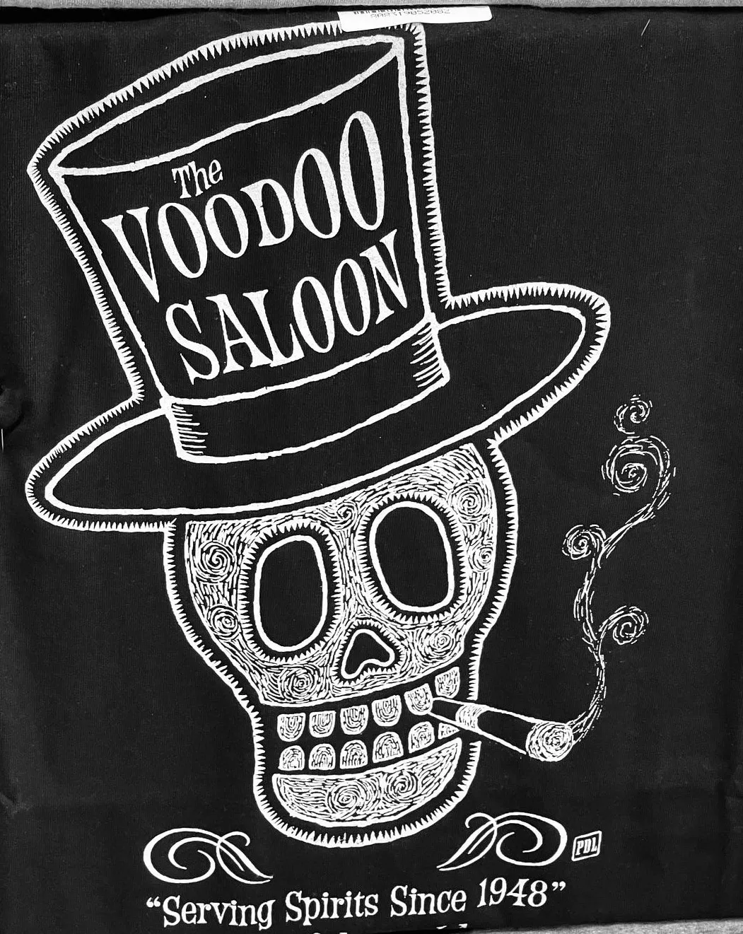 Skull with words “Voodoo Saloon” written across it. The saloon’s tagline: Serving spirits since 1948.