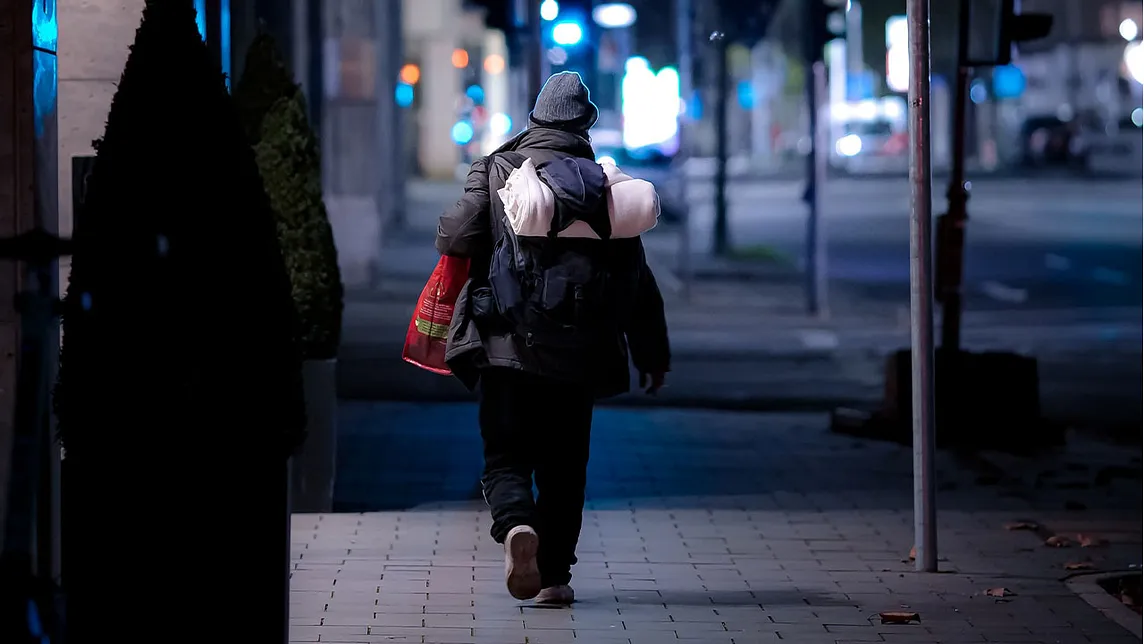 A homeless person navigating their way through the streets.