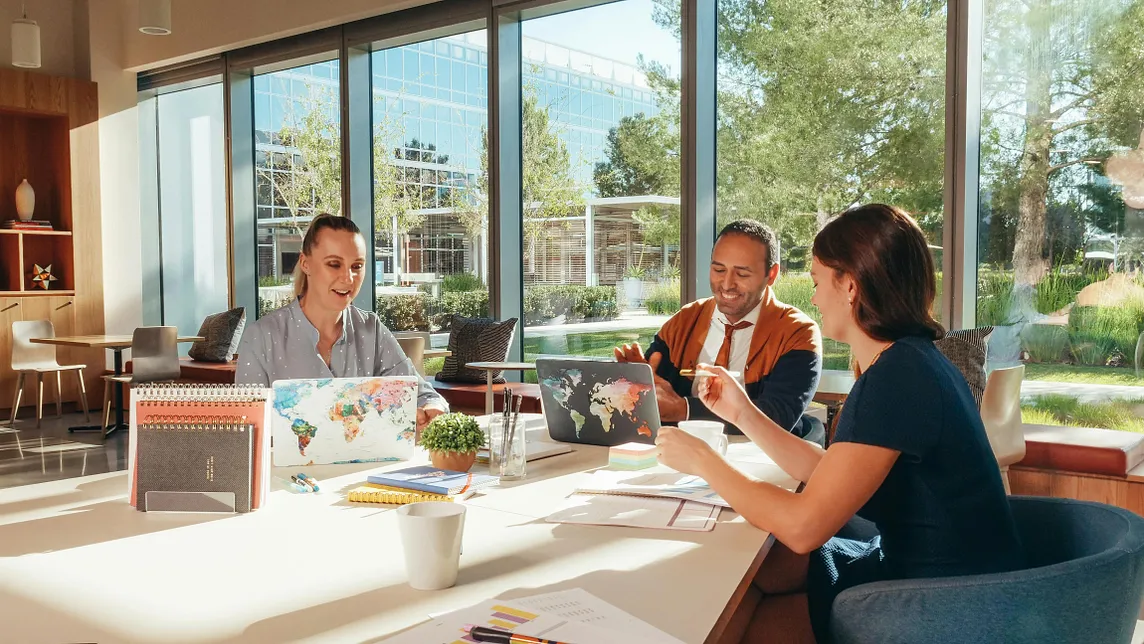 Team innovating around a desk in a sunlit, open office space. | Image by Kindel Media on Pexels