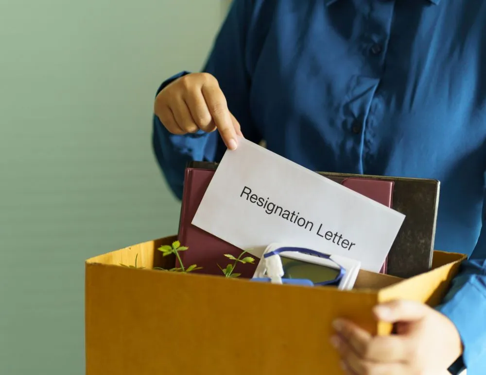 Image shows an office lady sending resignation letter and pack stuff