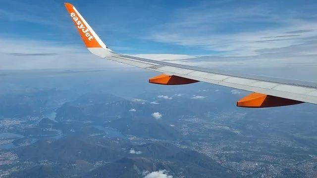 The wing of a plane flying over Italy.