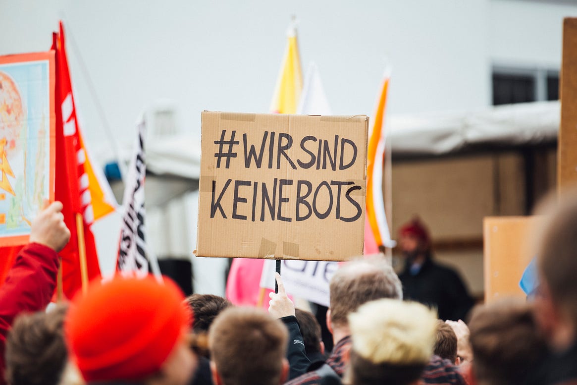 Picture of a crowd of protestors in Germany with a sign saying Wir sind Keinebots (We are not bot).
