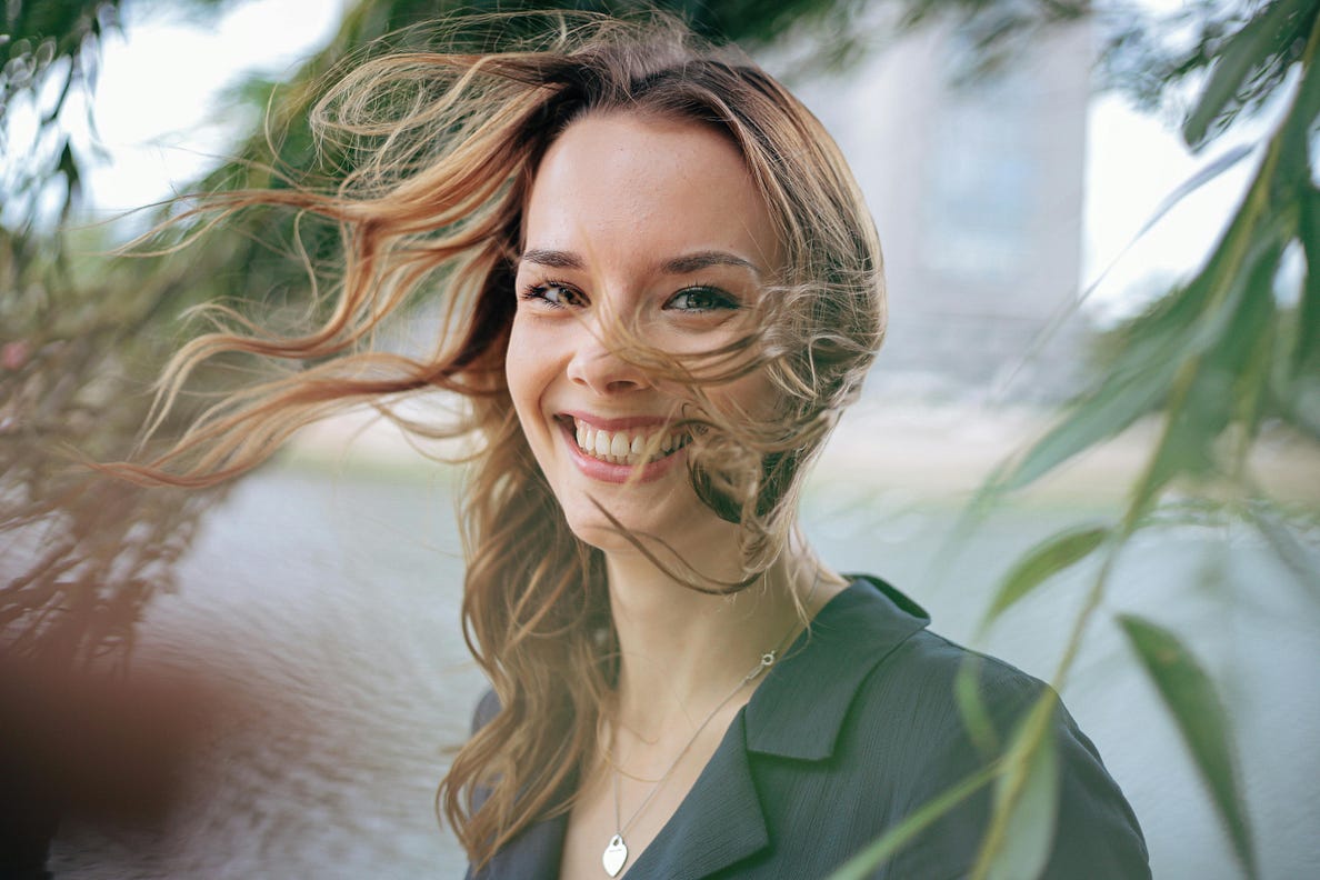 Smiling Woman with Long Hair. What happens when you do a happiness-boosting challenge for 28 days.