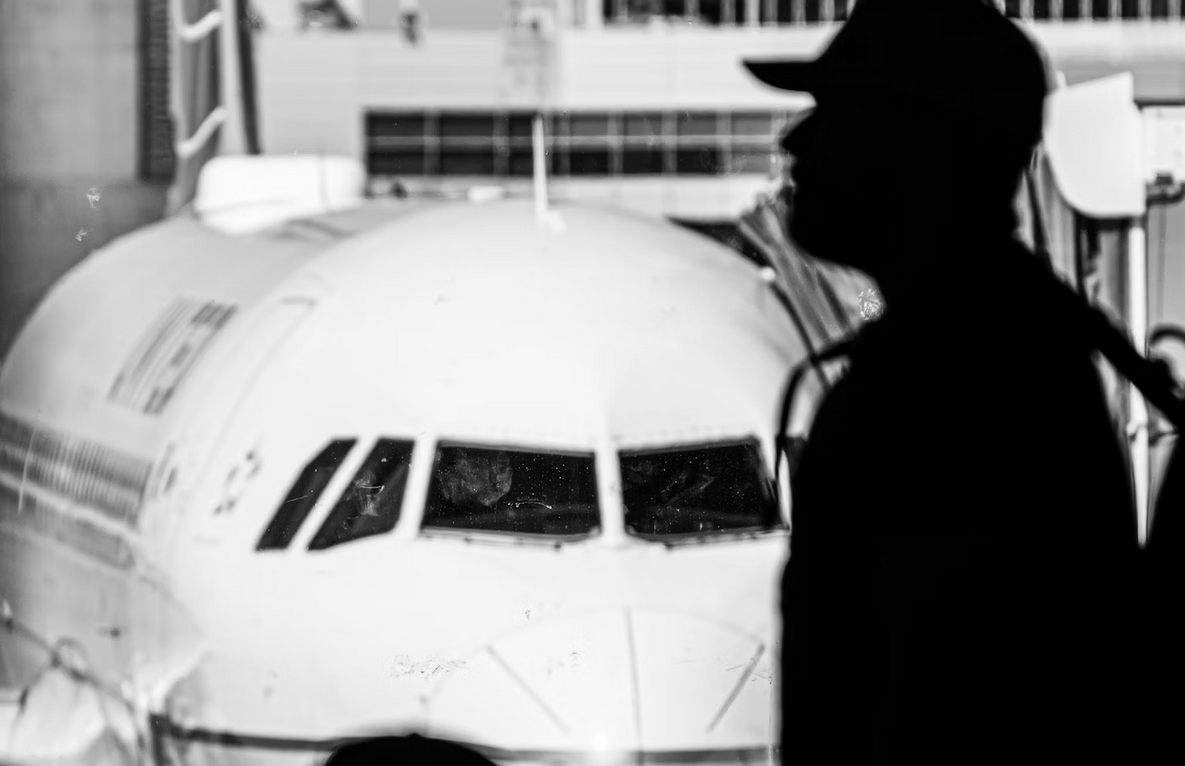 a man stands next to a plane. lights effect
