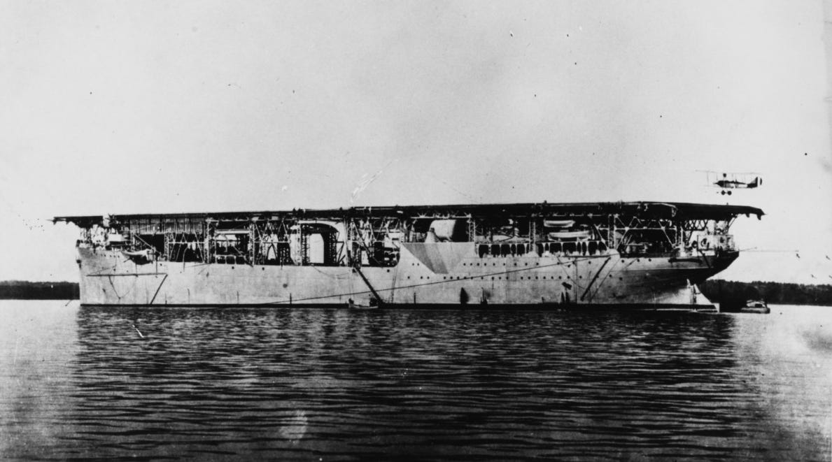 Aircraft carrier Langley (CV-1) with an Aeromarine plane landing while the ship was at anchor, circa 1923. Naval History and Heritage Command photograph, NH 93176.