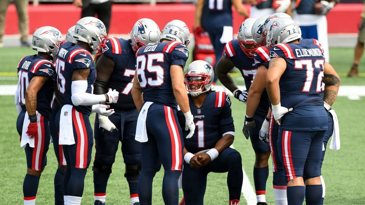 The Patriots offense huddling and discussing the gameplan