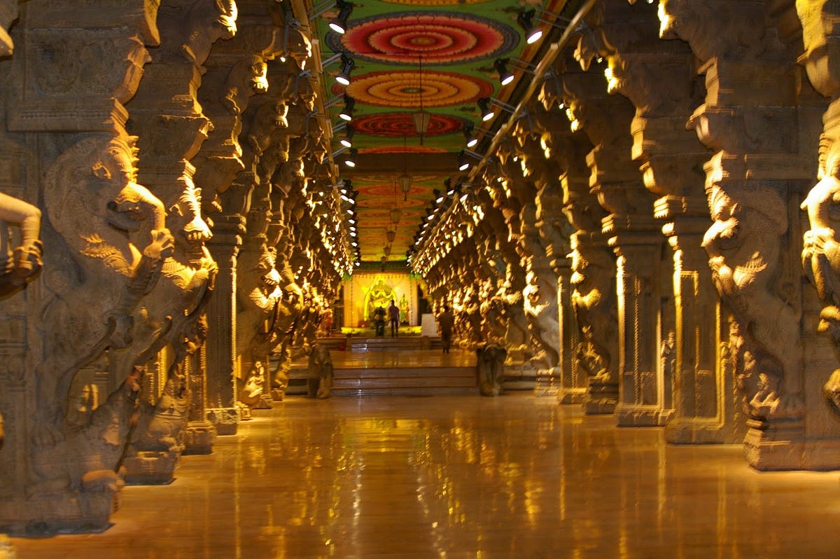 Intricate corridor pillars with sculptures of deities in Meenakshi Temple
