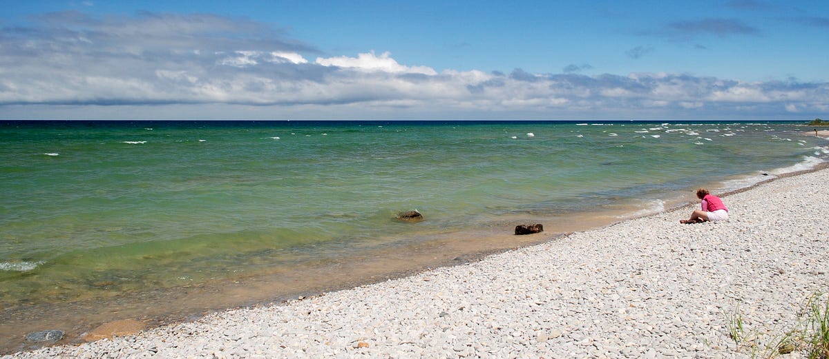 Petoskey Stones. She sits with the stones, by Chris Fletcher Medium