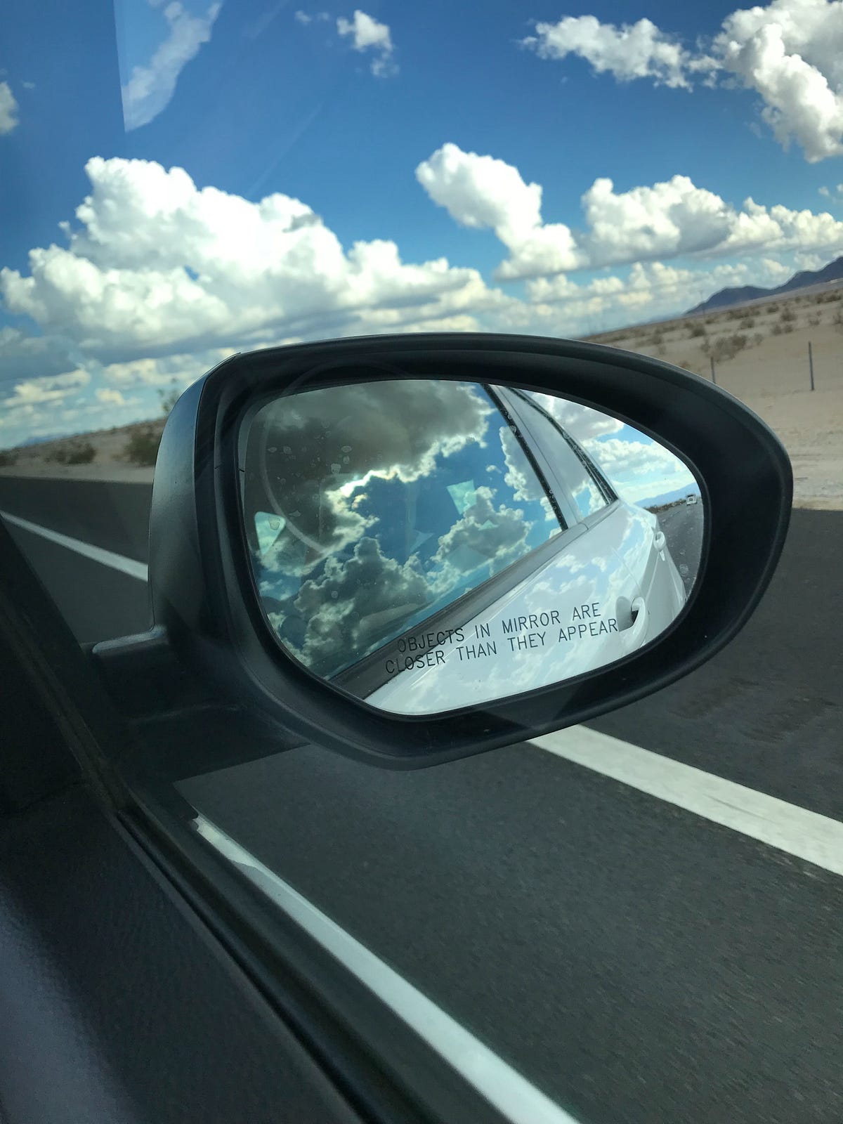 Why are objects in the side-view mirror closer than they appear?