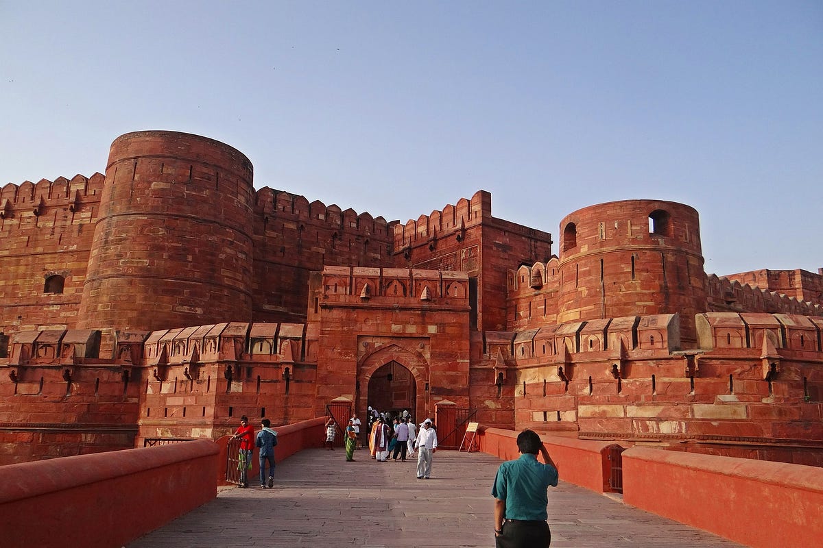 The Agra Fort, a historical marvel, at sunset, with the Yamuna River flowing gently in the background