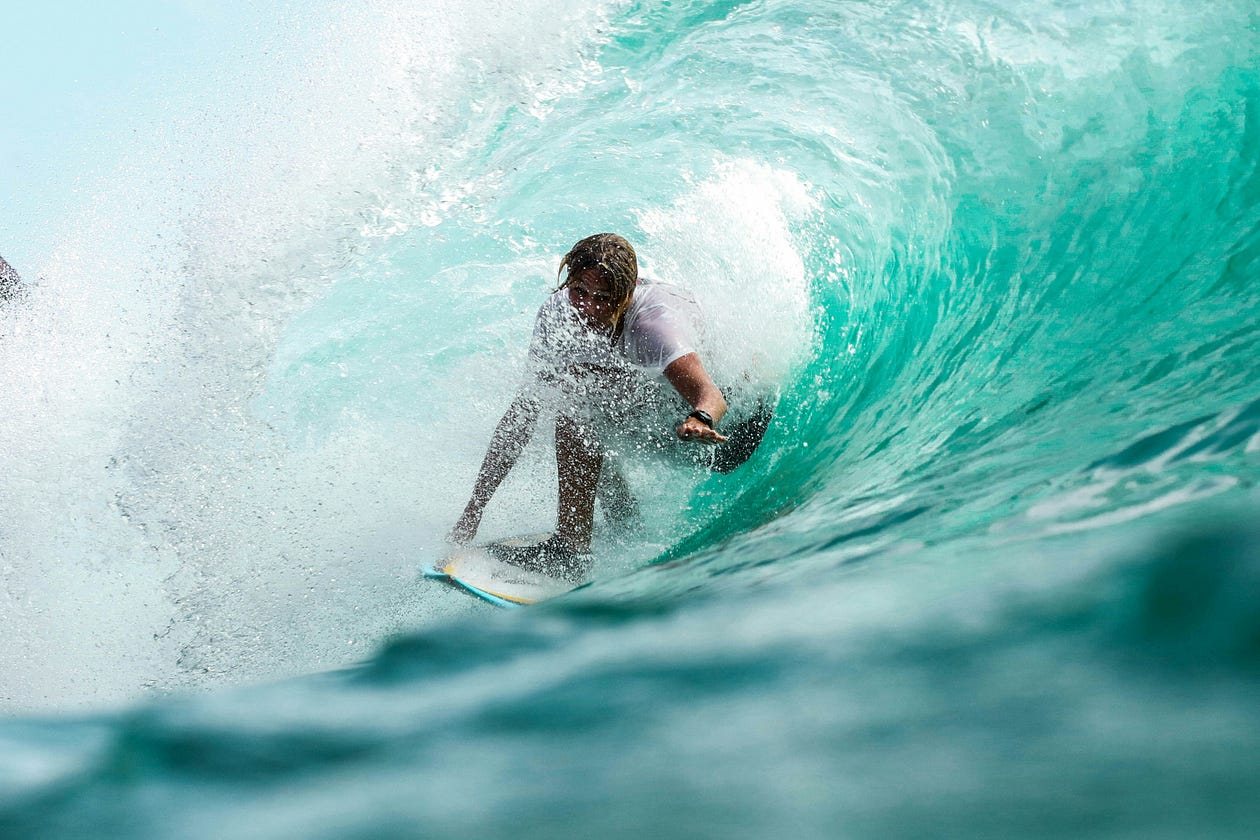 Color image of a cool surfer dude in the heart of a barrel wave, which is a type of wave that forms a hollow tube, or tunnel, as it breaks.