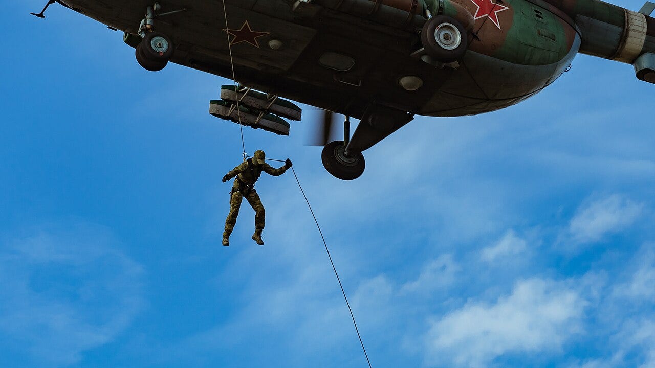A Russian special forces soldier jumps from a Mi-8 helicopter, securing himself with a rope, 20 August 2020