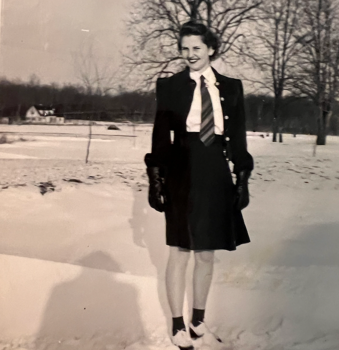 눈 내리는 날, 치마, 블라우스, 넥타이, 코트로 구성된 제복을 입은 10대 소녀가 배경에 벌거벗은 나무를 배경으로 야외에 서 있습니다.<BR>