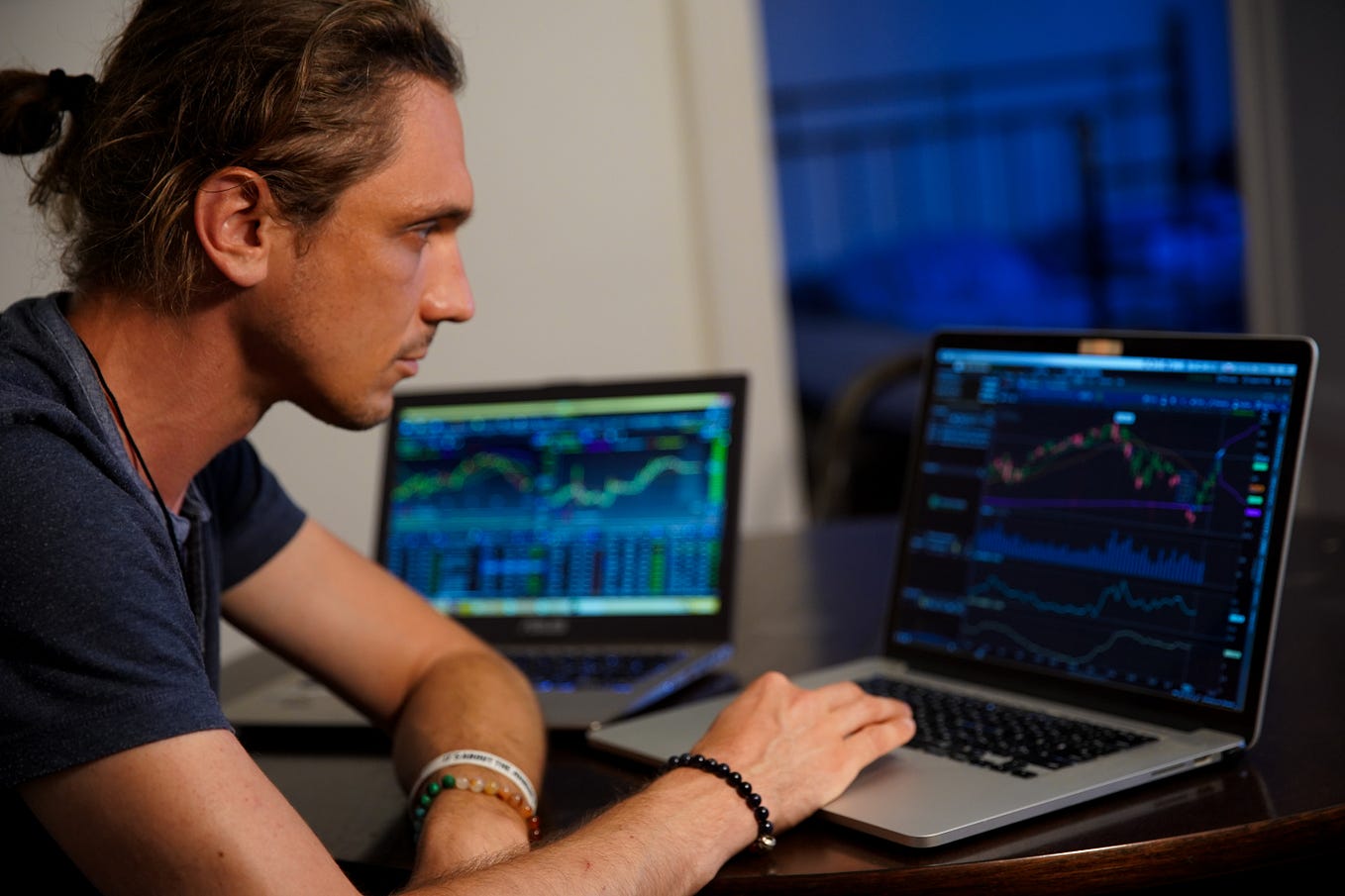Man sitting at a computer screen looking at trading charts.