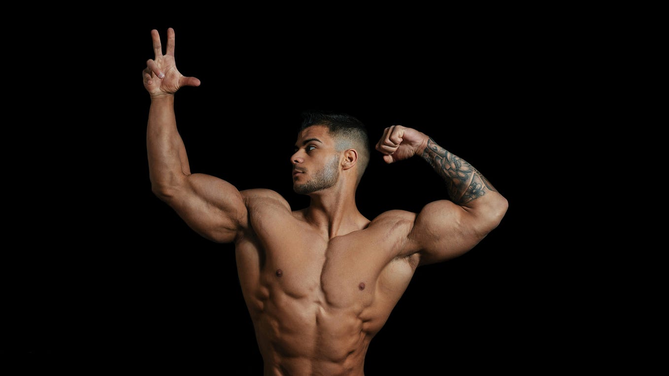 A man in a bodybuilder’s hero pose.