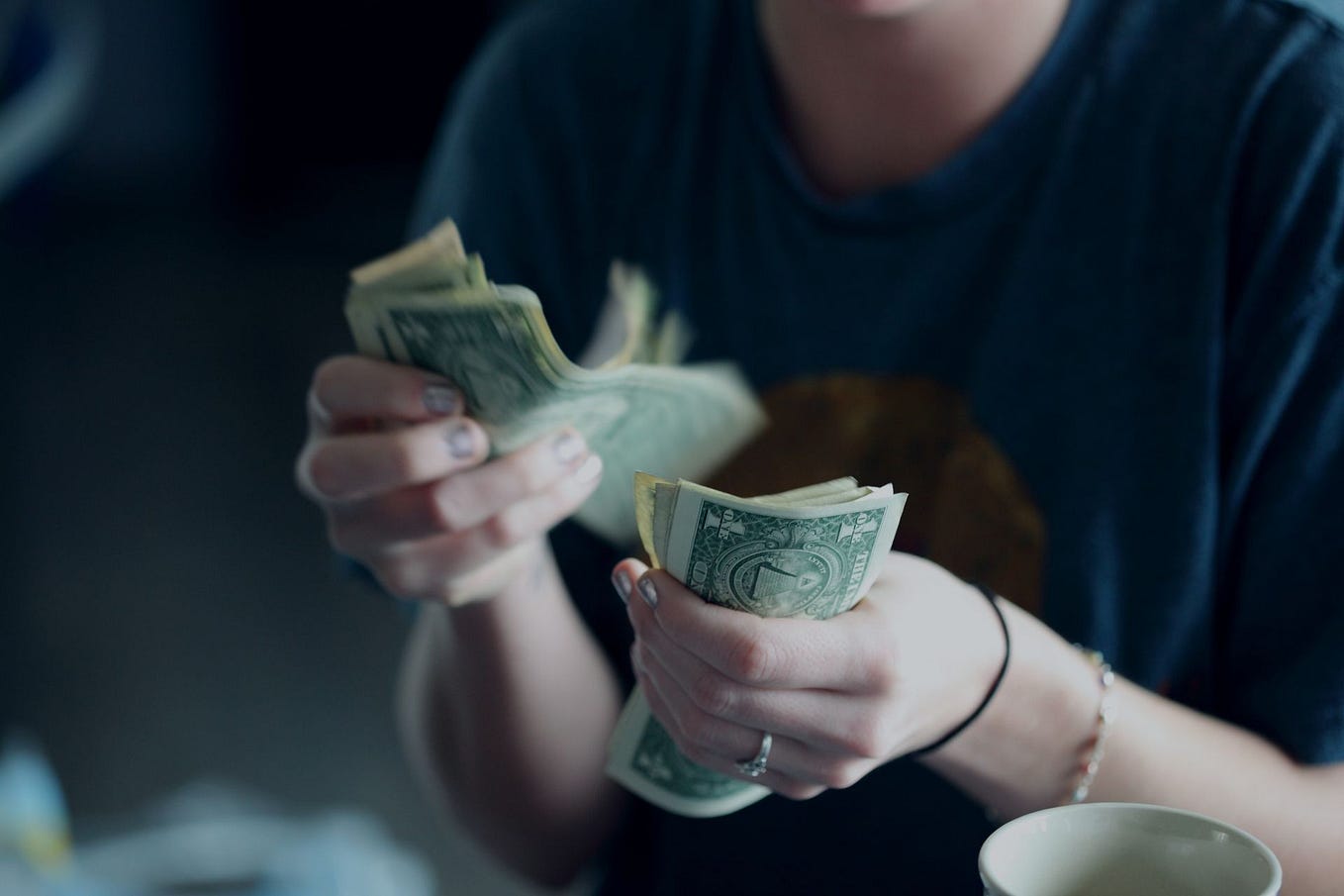 A twenty-four year old white woman counting dollar bills to represent stealing money.