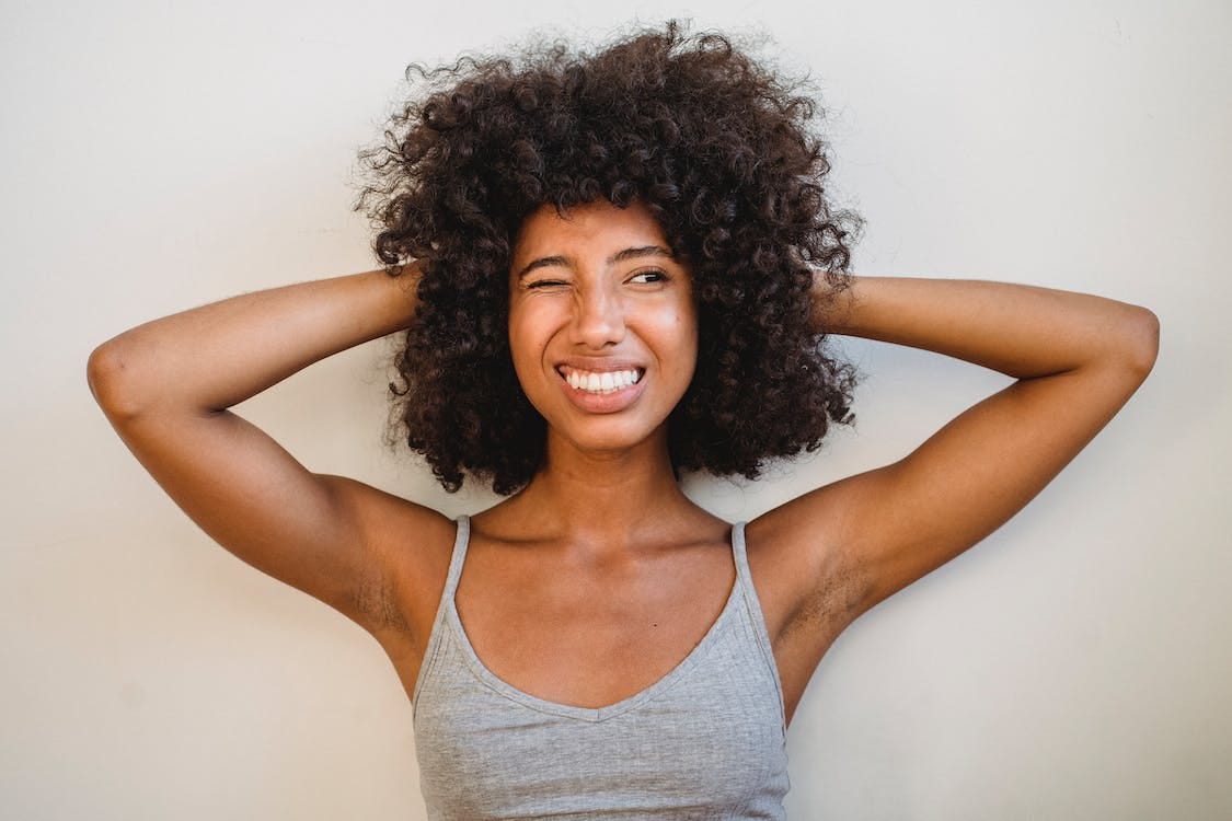 Charismatic black woman against white wall
