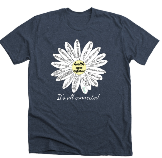 Blue tshirt with a daisy flower on it. In the center it reads ‘health care reform.’ On the petals around it are issues including Rx prices, education, clean air & water, voting rigths, anti-trust, affordable housing, food security, and more. Below the flower it reads ‘It’s all connected.’
