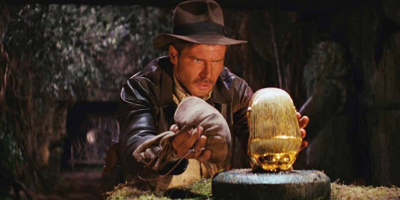 Indiana Jones preparing to grab an idol from a pedestal