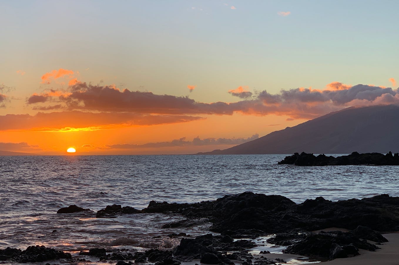 West Maui rises in the distance in a sunset photo taken from Kamaole Beach Park III.