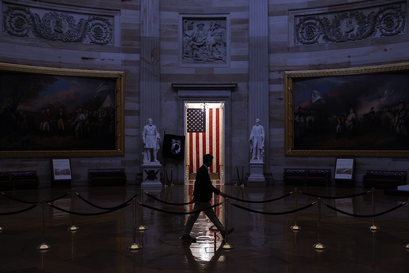 A man walks through the U.S. Capitol Rotunda, empty of tourists as only essential staff and journalists are allowed to work.