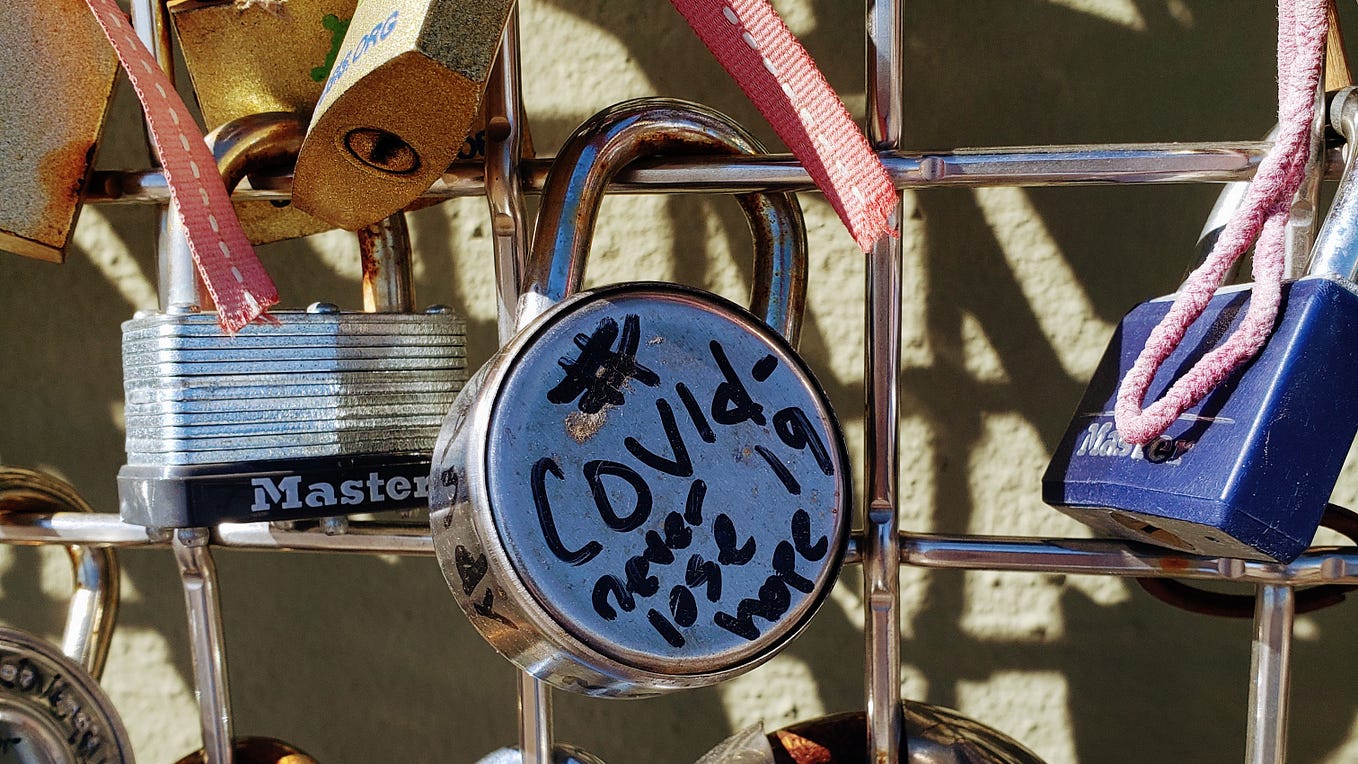 Picture of a lock on a gate that reads “COVID19 never lose hope”