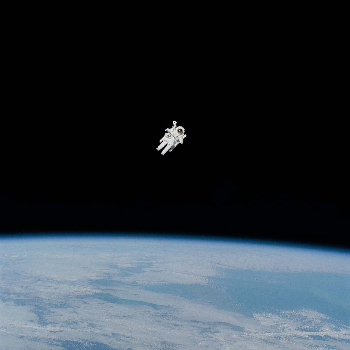 A lone astronaut in space, floating over Earth