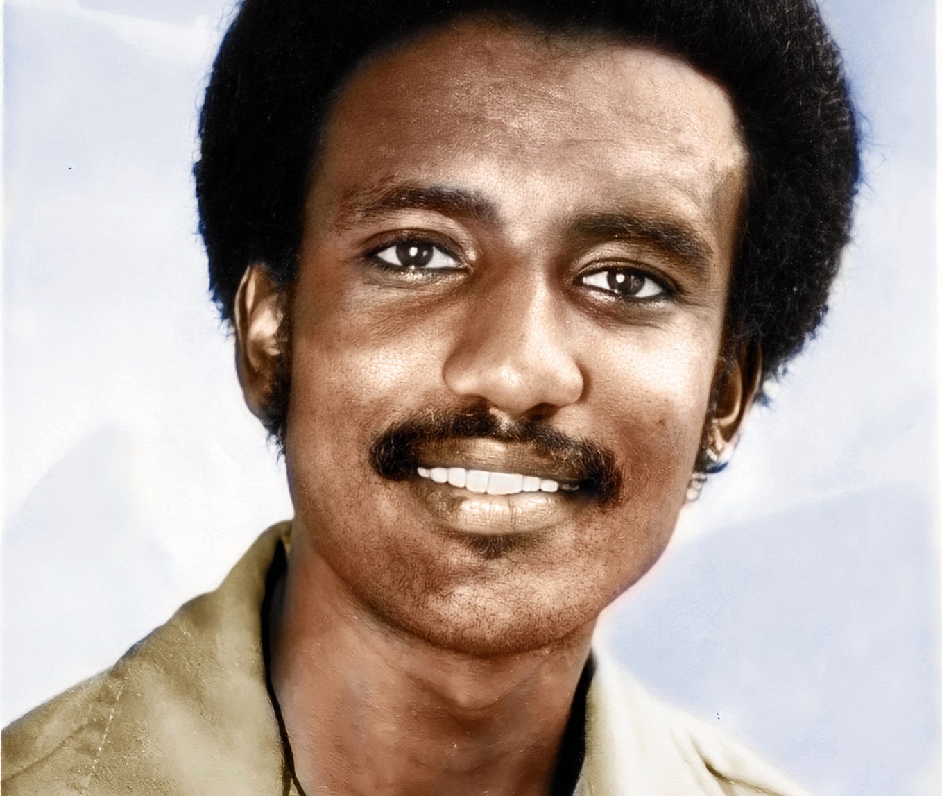 Portrait photo of a young, smiling Black man.