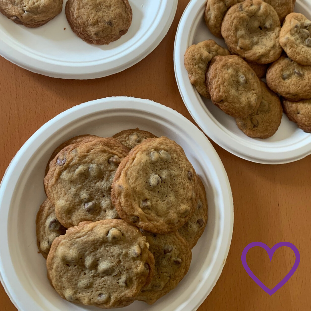 a plate of chocolate chip cookies with a purple heart in the corner