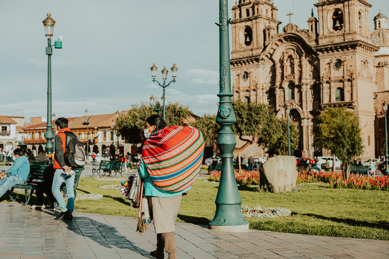 A Quechua woman in traditional clothing carries a bundle of goods in central Cusco, Peru.