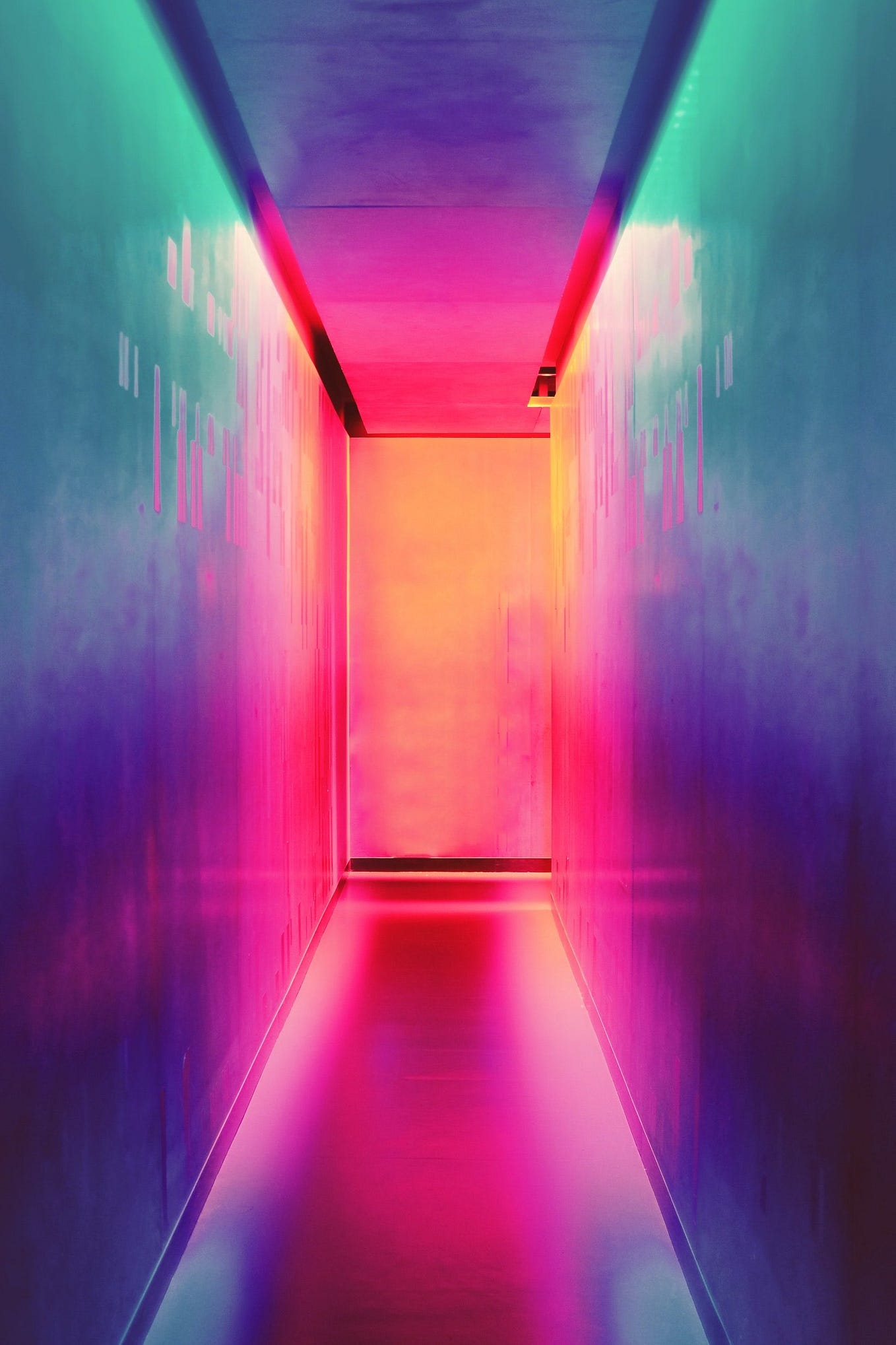 Long brightly colored corridor with an open door at the end.