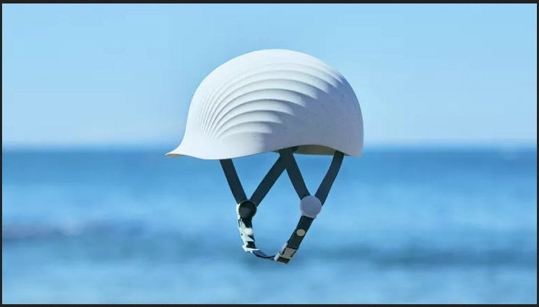 A white helmet made from discarded scallop shells, against the backdrop of the ocean.