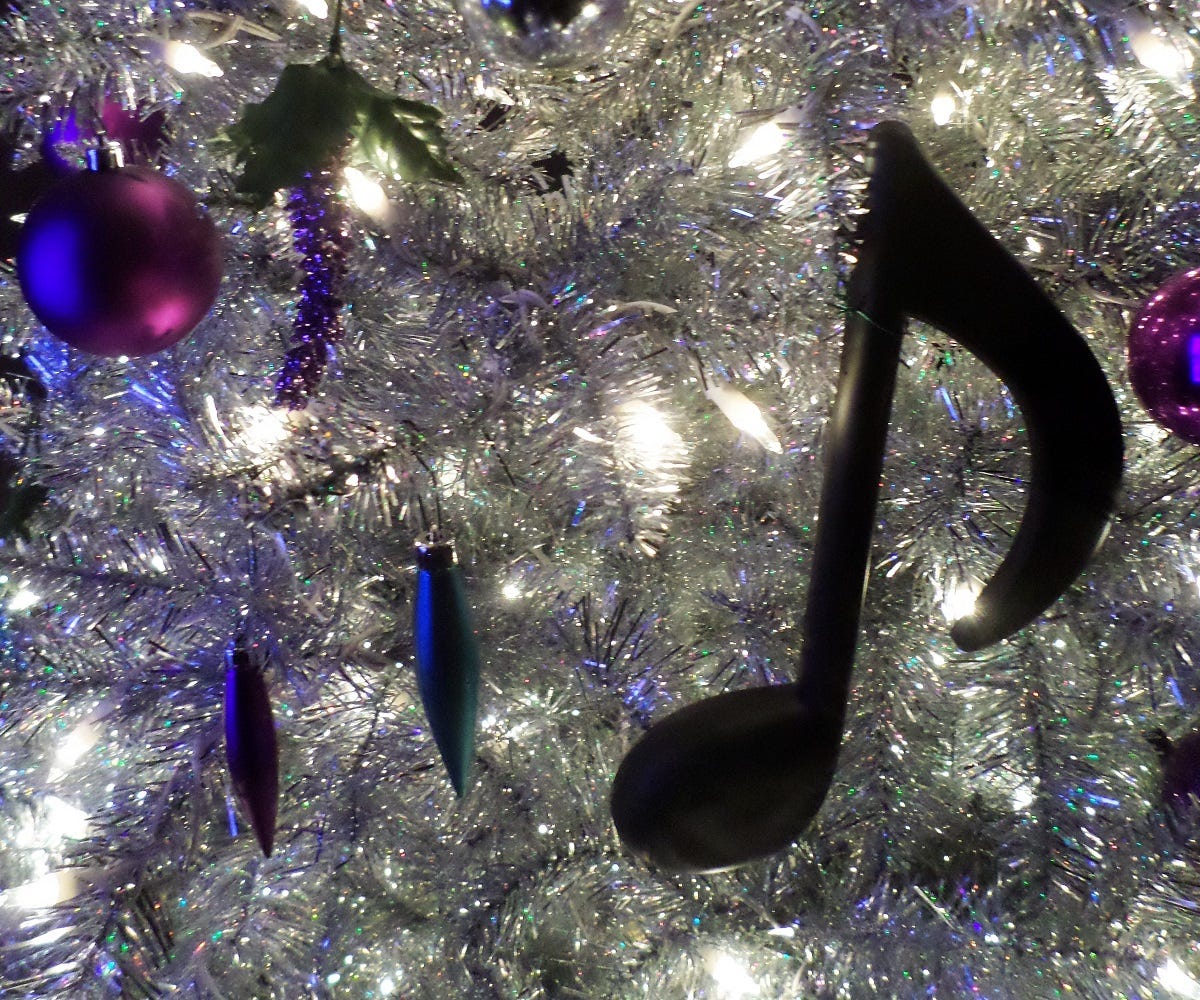 A close-up shot of a silvery Christmas tree with musical note ornaments.
