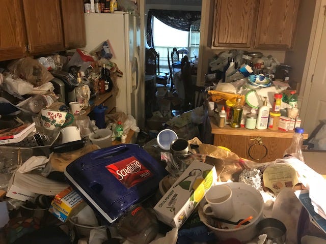 Gina’s kitchen — with counters filled with trash and debris