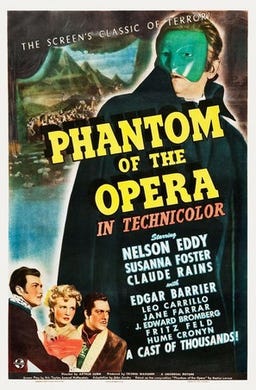 A movie poster for the 1943 version of The Phantom of the Opera. Claude Rains is shown looming large, wearing a green mask. The other actors are shown to the left. The brightly colored poster states “in Technicolor” below the bright yellow title and lists the stars as Nelson Eddy, Susanna Foster, and Claude Rains.