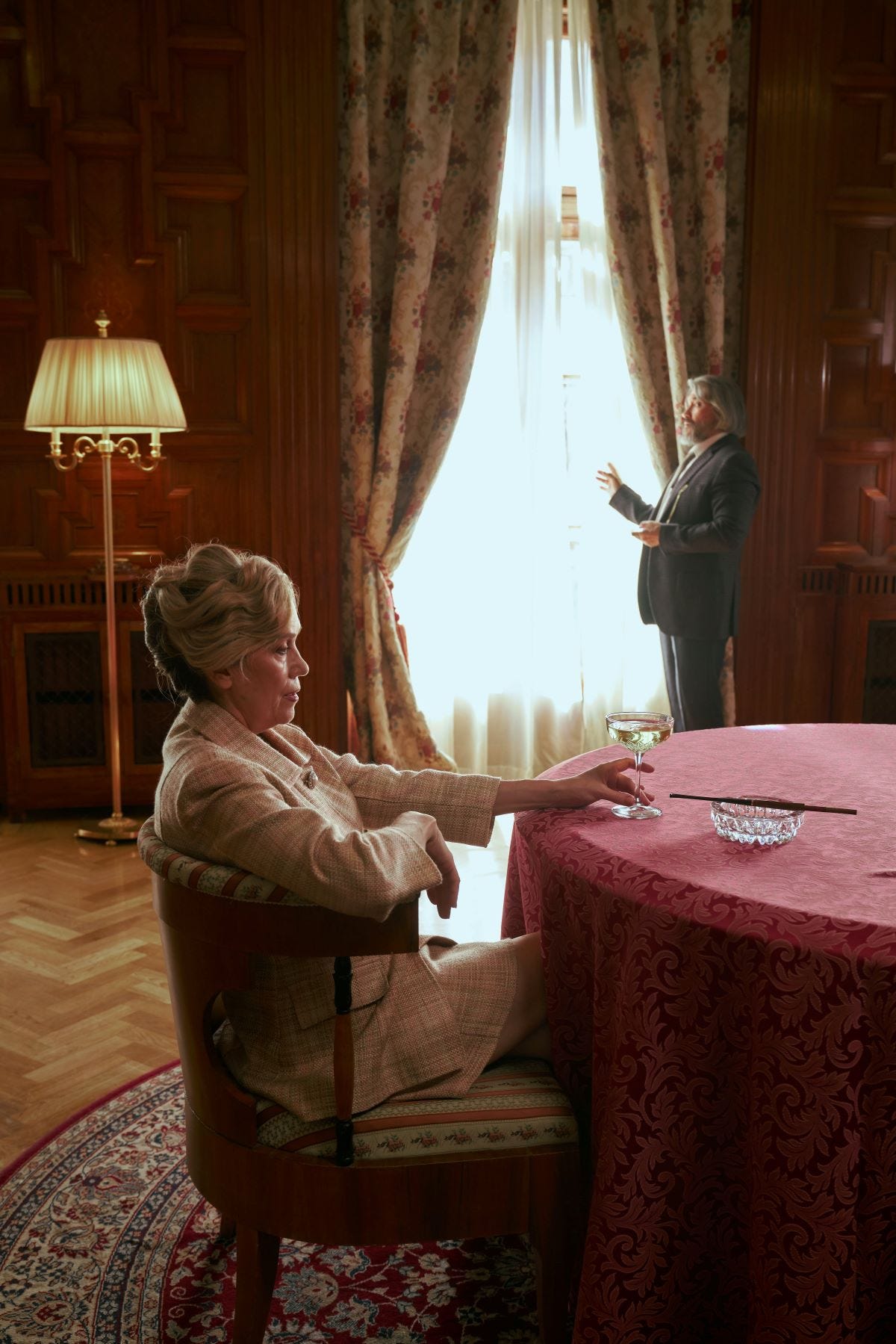 A wealthy older couple in a finely appointed great room.