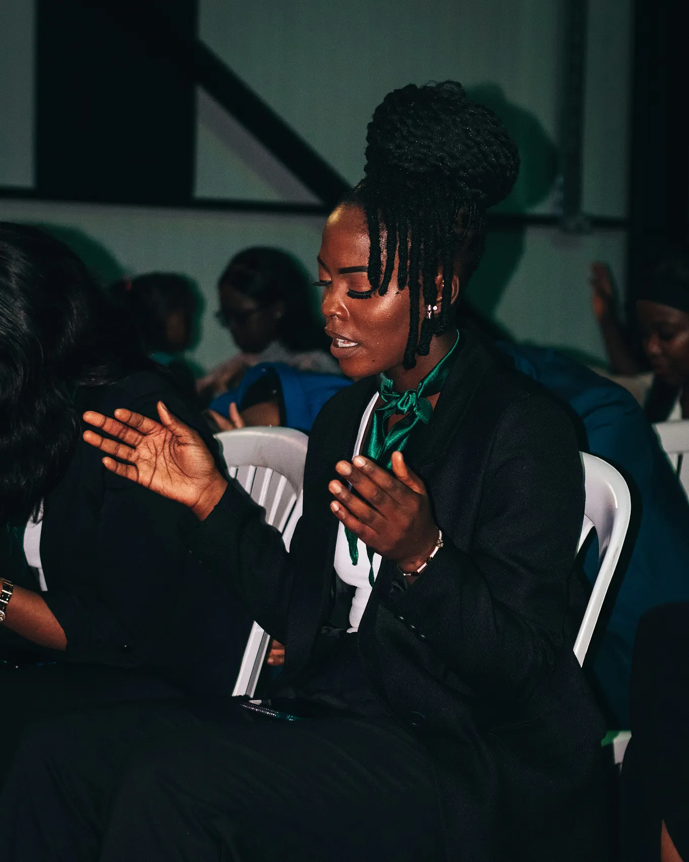 The photo shows a young woman with her eyes closed and her hands slightly raised in prayer.