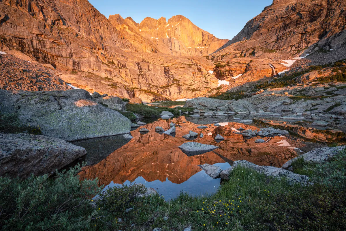 A majestic mountain reflected in an alpine lake at sunrise.