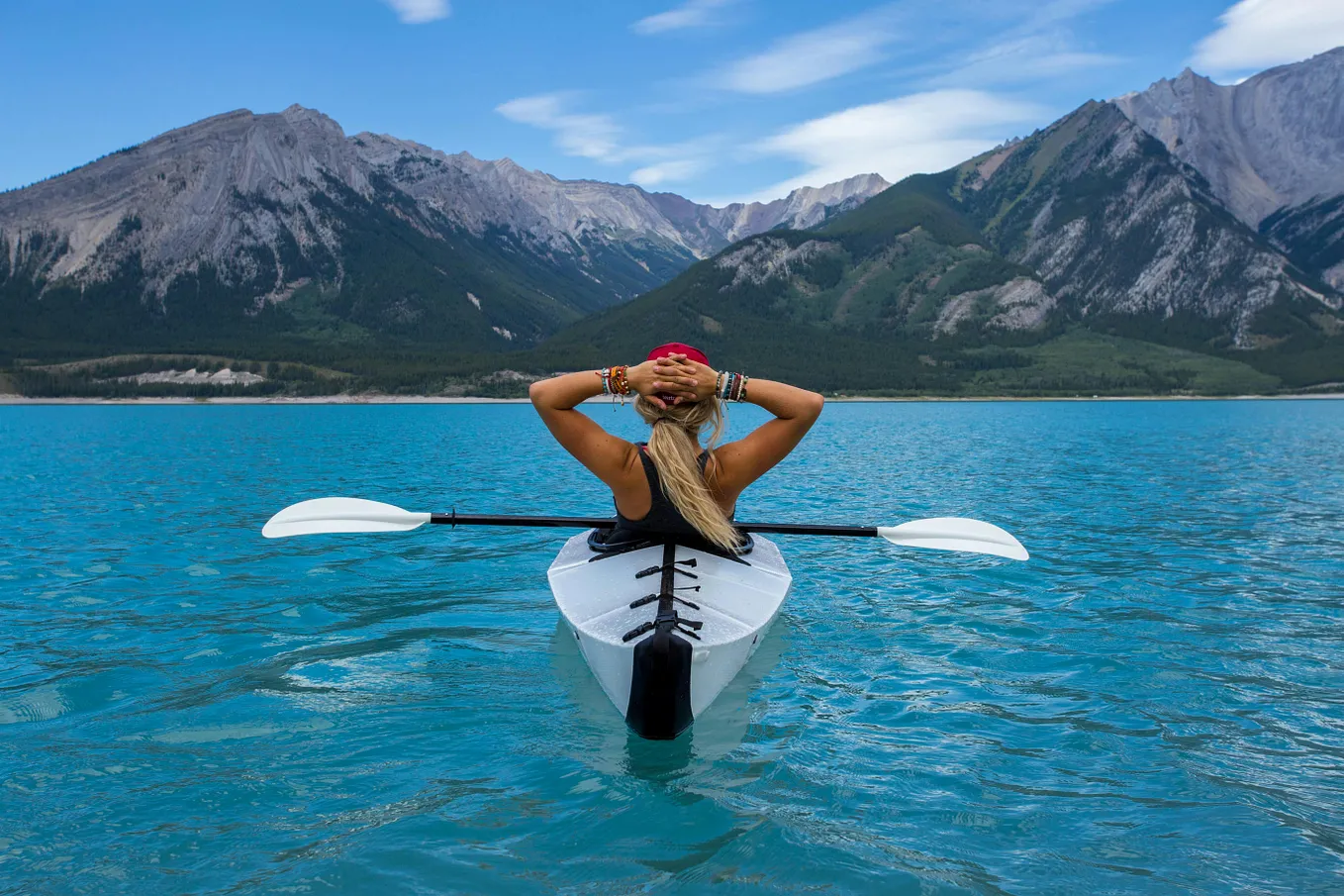 Woman in a kayak, pausing to enjoy the mountain view