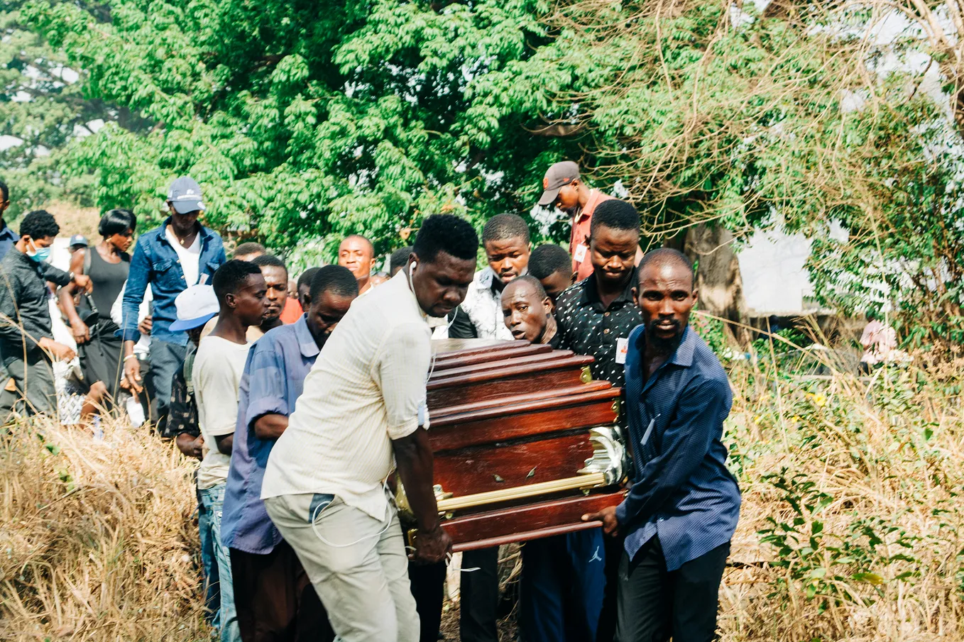 The writer pictures a funeral procession and pallbearers carrying a casket across a grassy area.