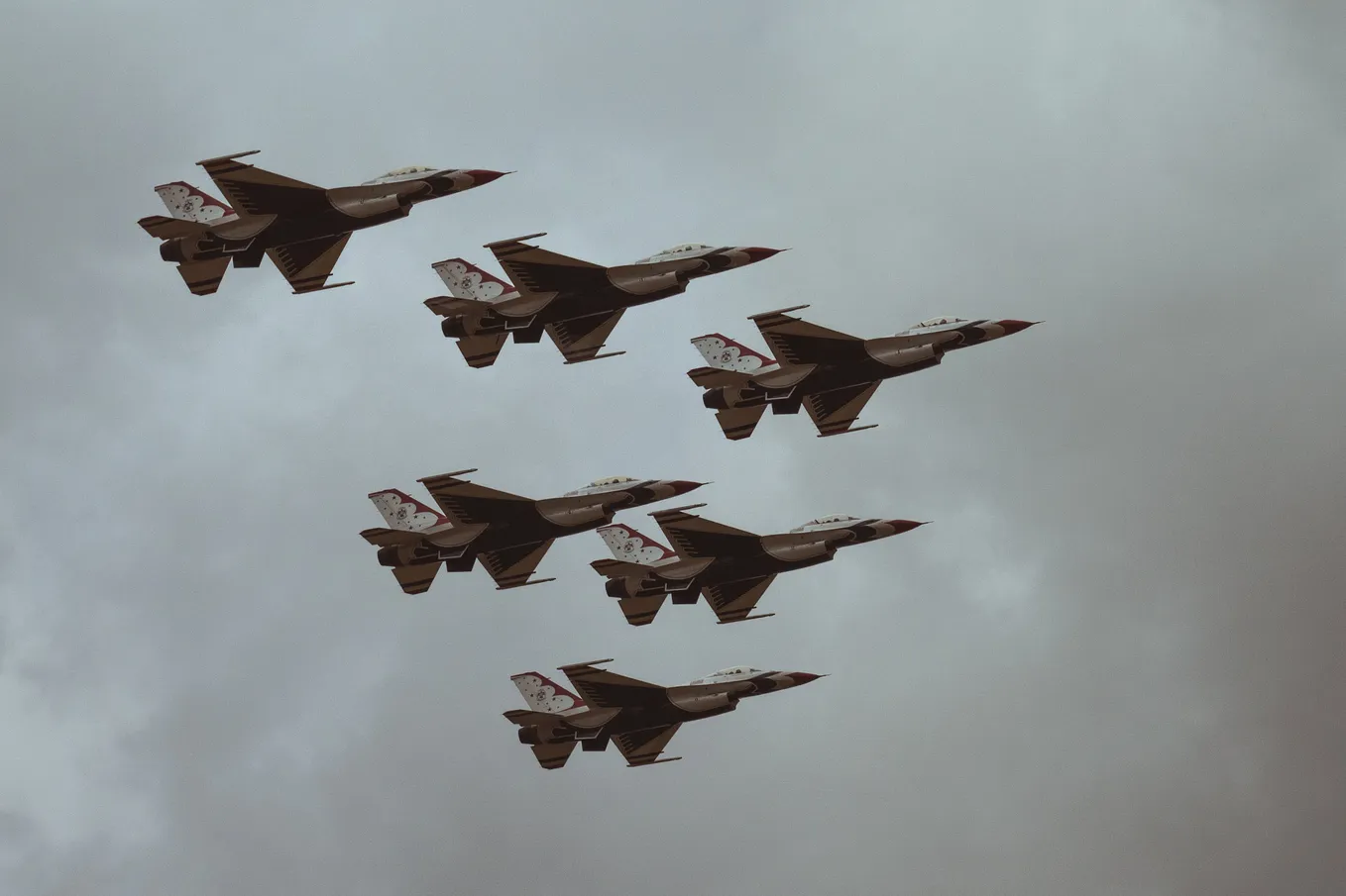 Five fighter jets flying across the sky.