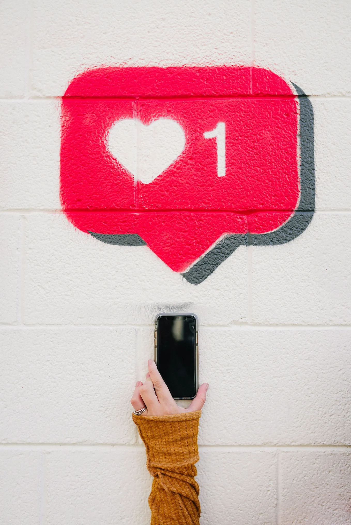 A spray-paint artwork of a ‘one like’ symbol on a wall above someone stretching their mobile phone upwards, creating the illusion that the symbol is coming from said phone. It’s all much pithier than this description makes it sound, but sometimes things are hard to explain.