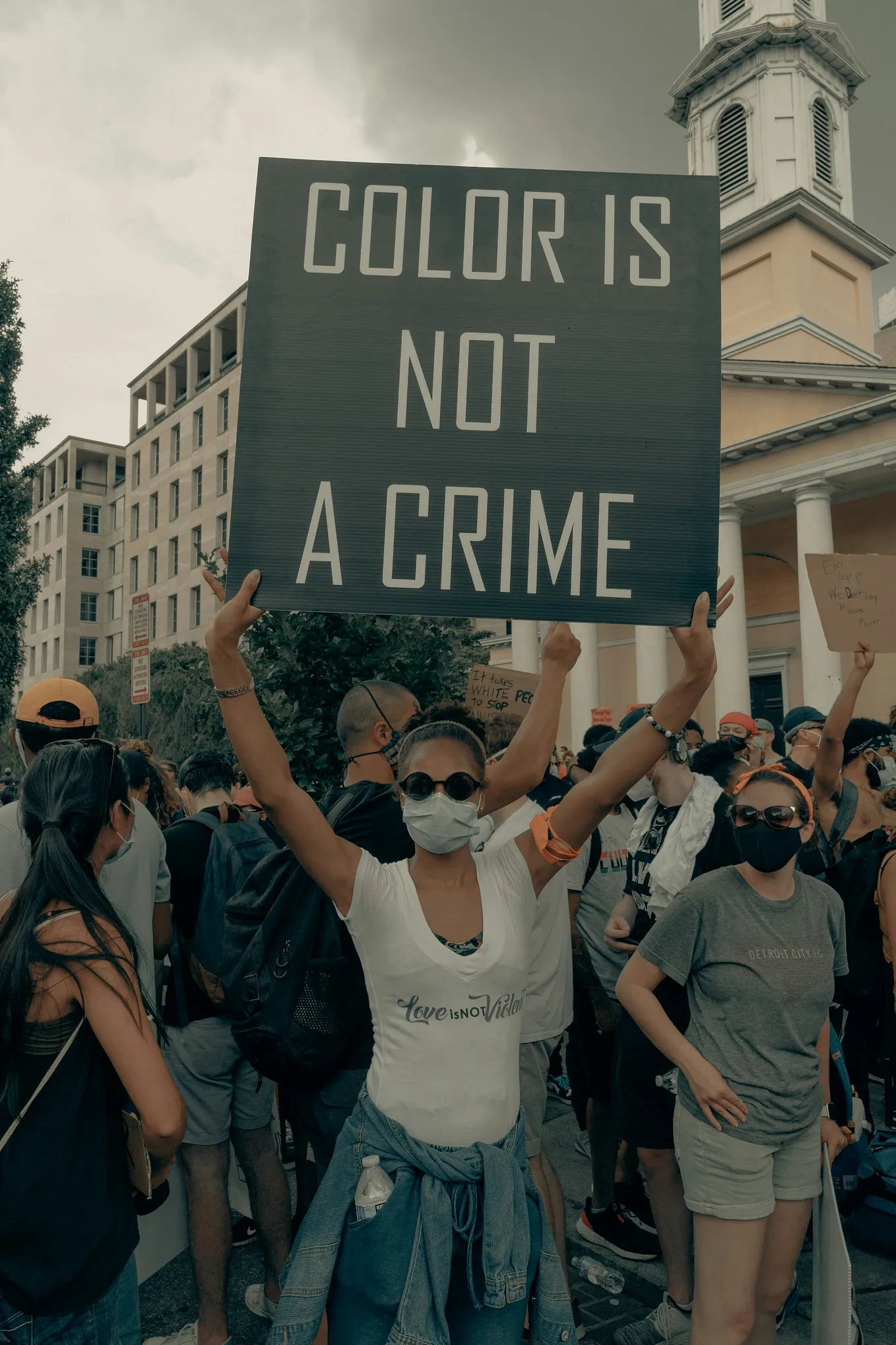 Anti-racism placard held by a woman at a protest.