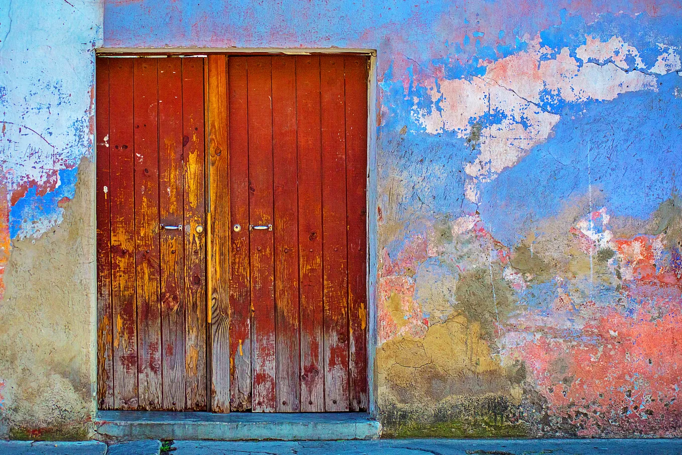 A red door on a colorful wall