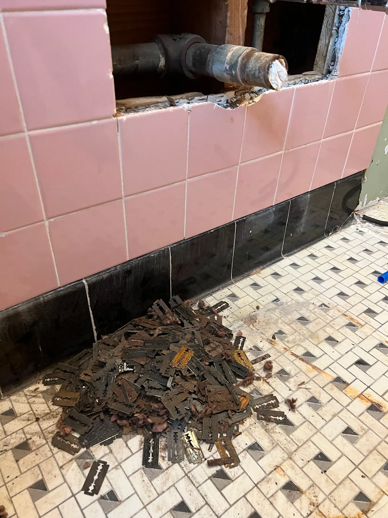 A large pile of razor blades discovered behind the wall in the orginial bathroom.