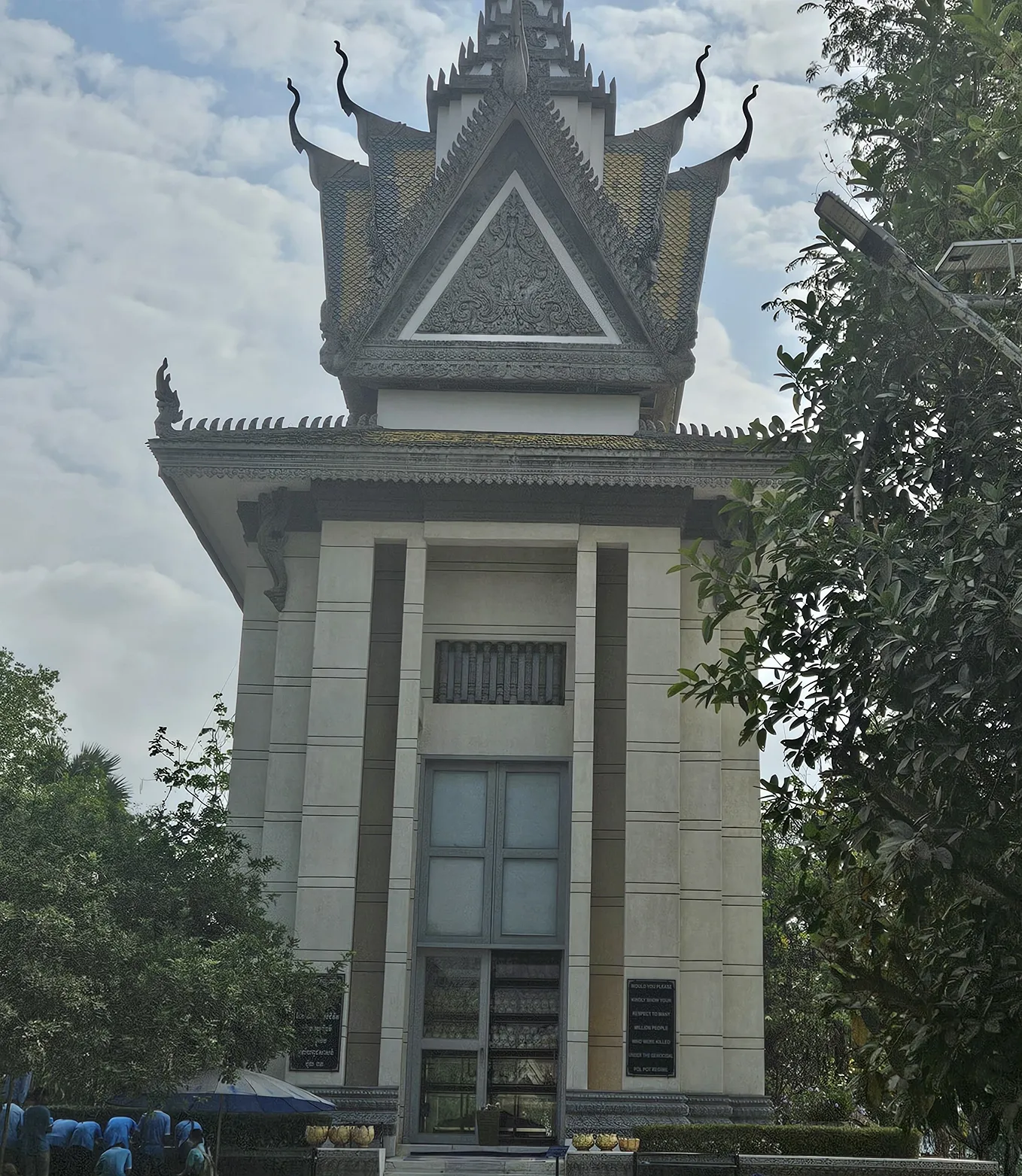 Choeung Ek Genocidal Center memorial. white concrete with a pagoda style roof.