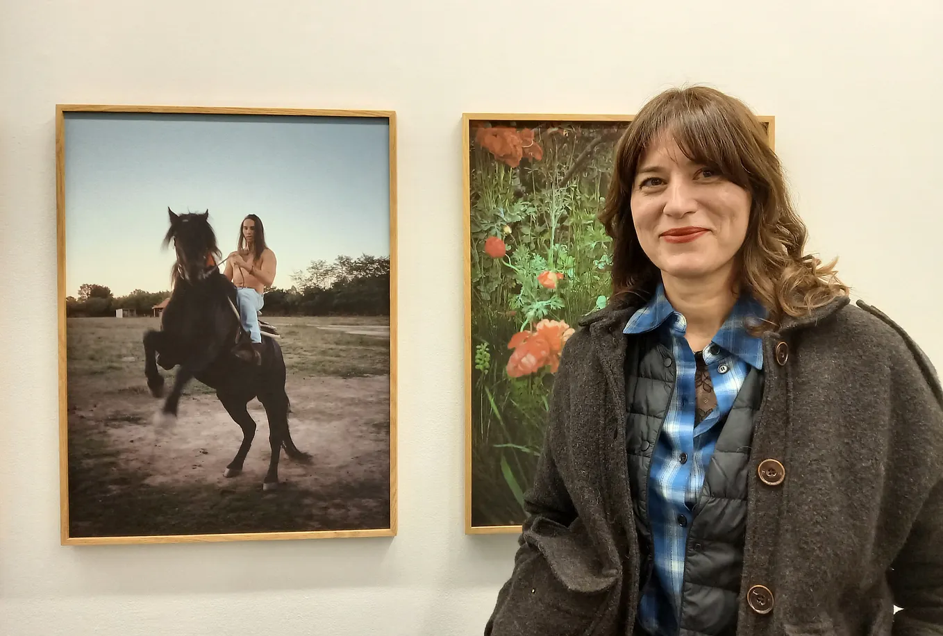 Dragana Jurišiċ stands with two of her photographs from her exhibition The Last Balkan Cowboy in Dublin's Temple Bar Gallery. Photo: Clare O’Beara.