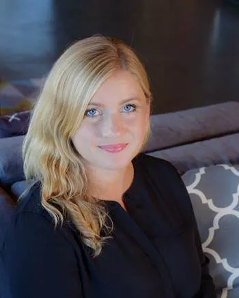 Smiling long-haired blonde white woman on a sofa