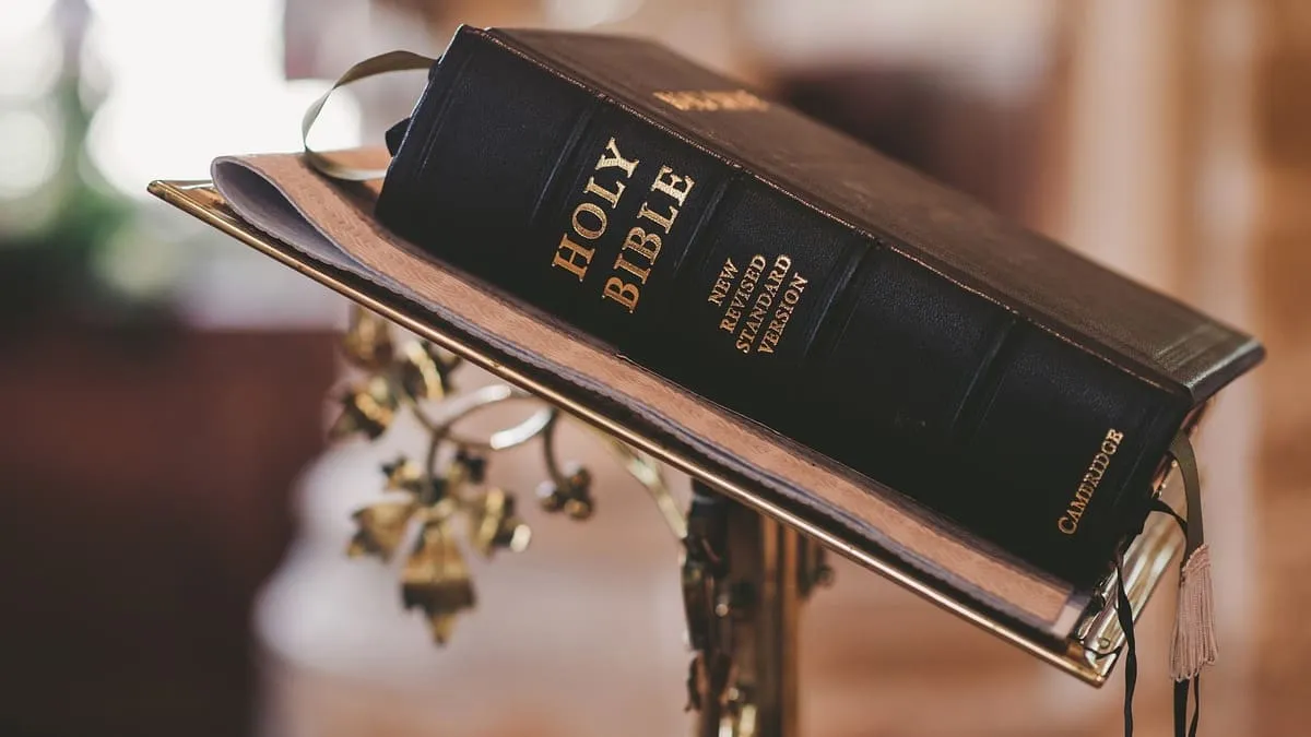 large black book with spine stamped Holy Bible resting on a lectern